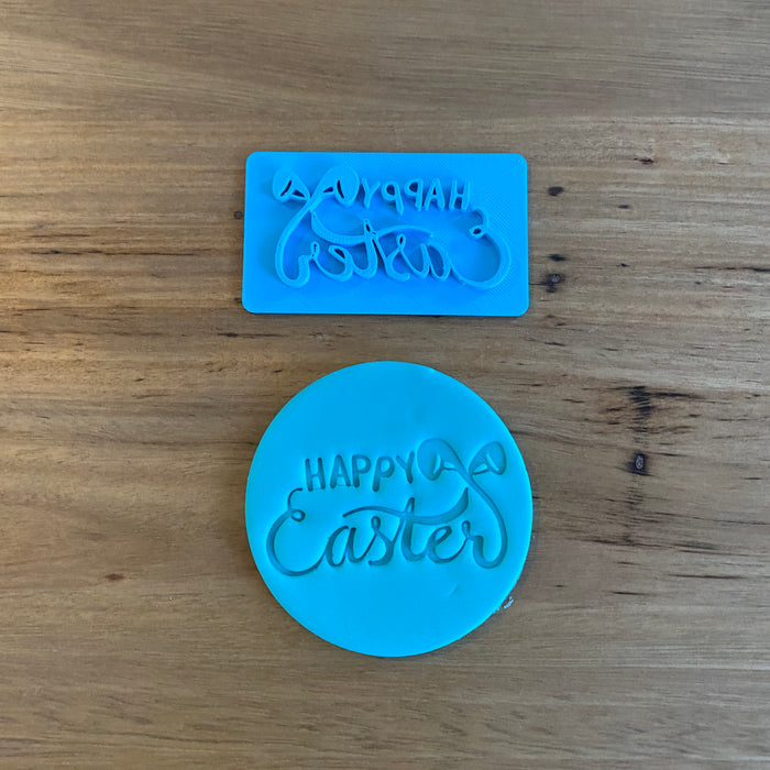 Happy Easter Style #1 Emboss Stamp. This stamp is designed to fit on a 70mm cookie. If required we can supply a 70mm cutter to suit this stamp   See our complete range by searching "Easter" in store.  Each stamp comes with a handle on the top to help with application and removal of the stamp. This significantly improves the quality of your finished cookie.