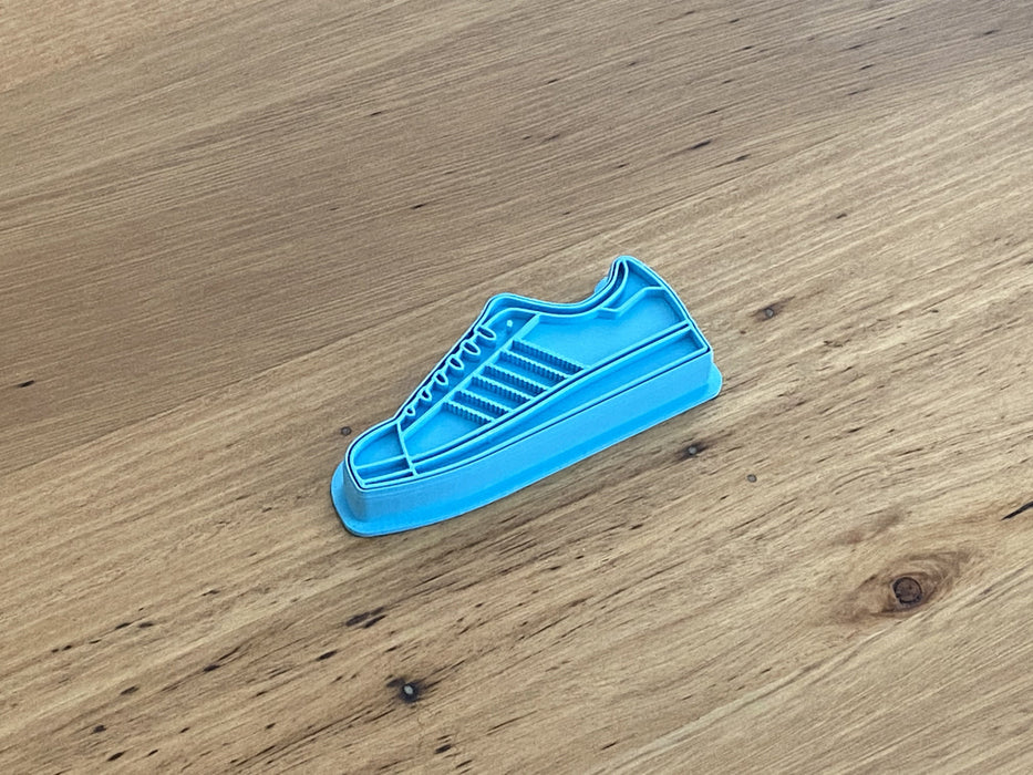Running Training Shoe style #2 Cookie Cutter and Stamp Set measures approx. 47mm tall by 90mm wide. Adidas Superstar Style.  This has the option of choosing the cookie cutter outline only or with the fondant stamp as a set.   